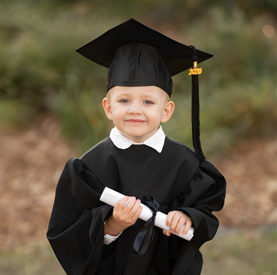Young boy in graduation gown holding a diploma during a Brisbane preschool graduation session by Little Star Photography