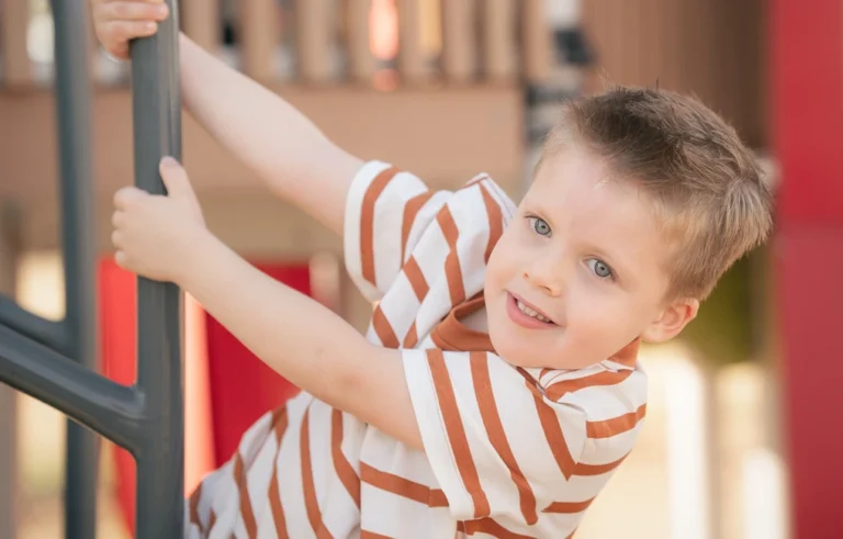 Young boy climbing playground equipment in Brisbane during a Little Star Photography session.