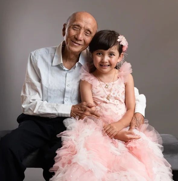 Grandfather and granddaughter sharing a warm moment during a studio portrait in Logan by Little Star Photography.