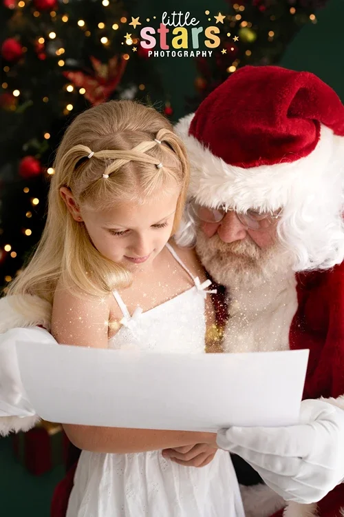 Young girl reading a glowing Christmas letter with Santa during a Brisbane photo session by Little Star Photography.