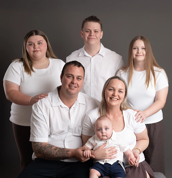 Mother, father and two children posing together during a family portrait studio session.