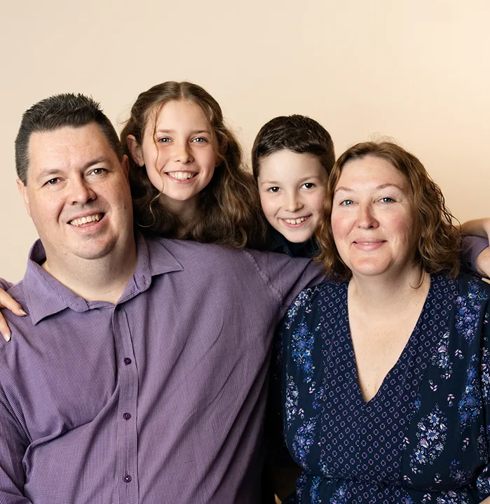 Large family group with parents, teenagers and baby during a large family studio portrait.